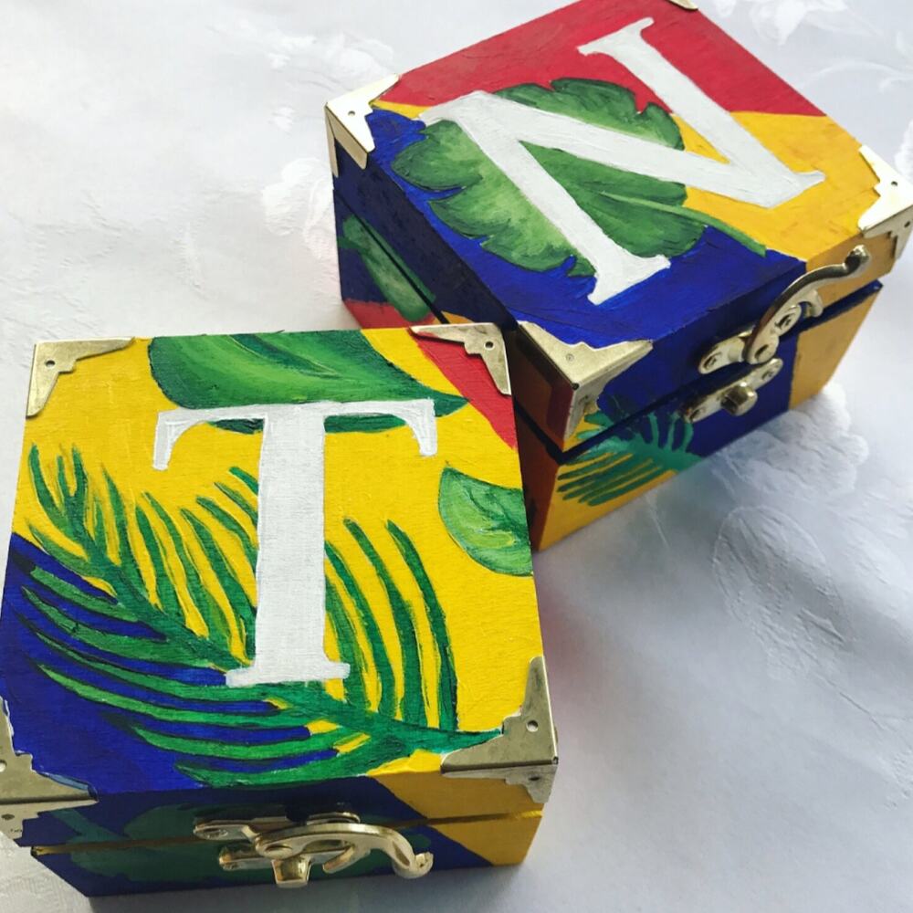 Two hand-painted wooden boxes with tropical leaf motifs by Antoinette Jordaine